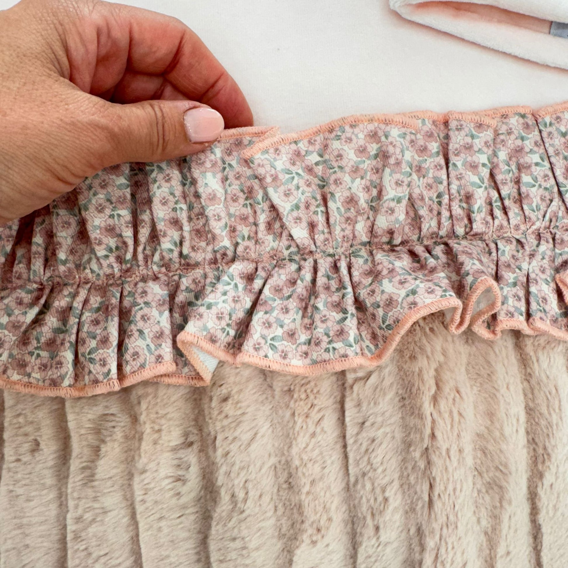 Cappellino rosa in ciniglia con inserto floreale, fiocchetto e bottone centrale