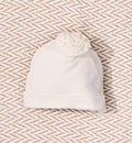 Cappellino neonata panna con dettaglio floreale tono su tono