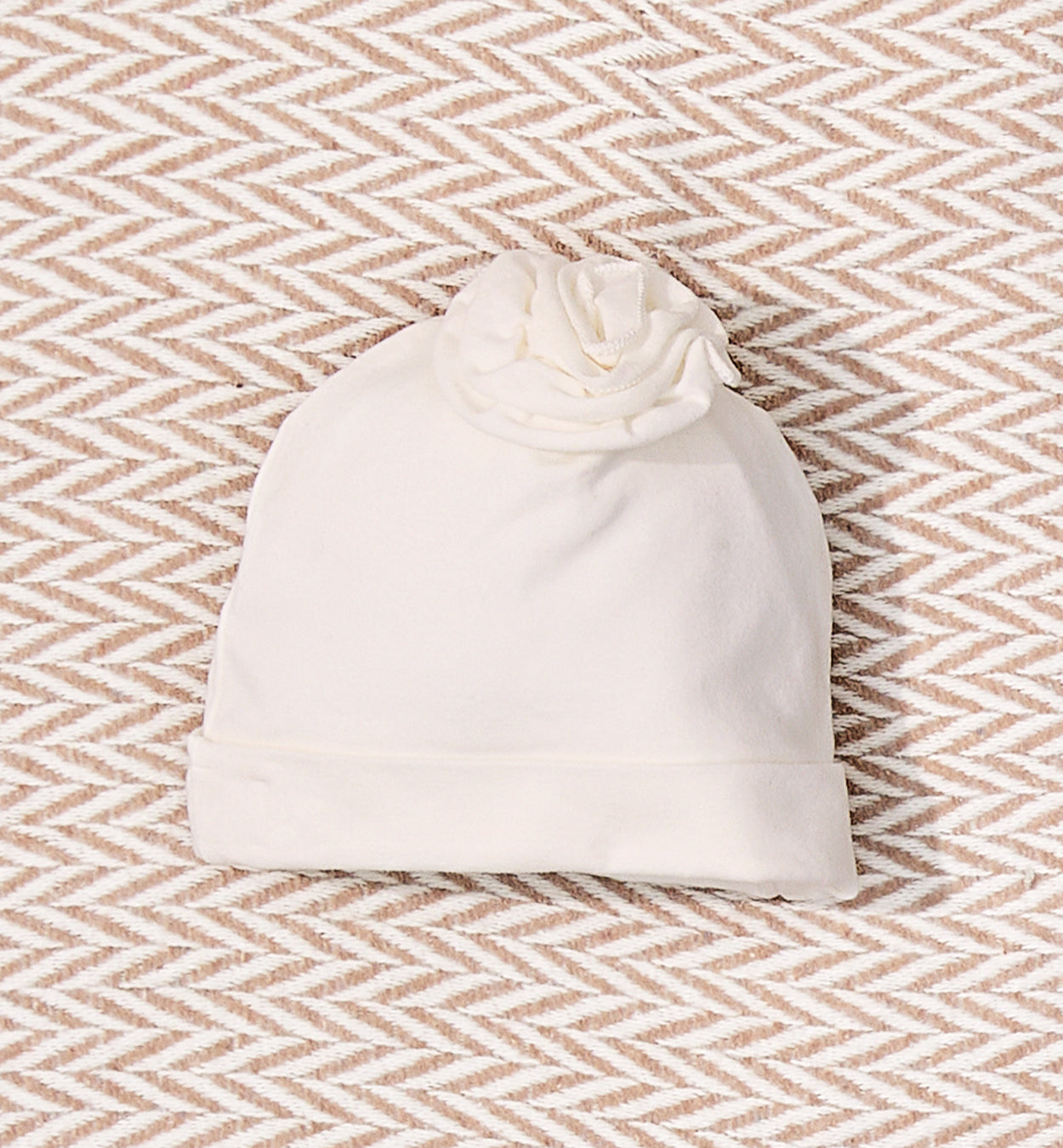 Cappellino neonata panna con dettaglio floreale tono su tono
