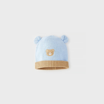 Cappellino neonato azzurro in maglia di cotone e lana con orecchiette, orsetto applicato e bordo risvoltato beige a costine.