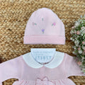 Dettaglio cappellino rosa con ricami floreali lilla e rosa