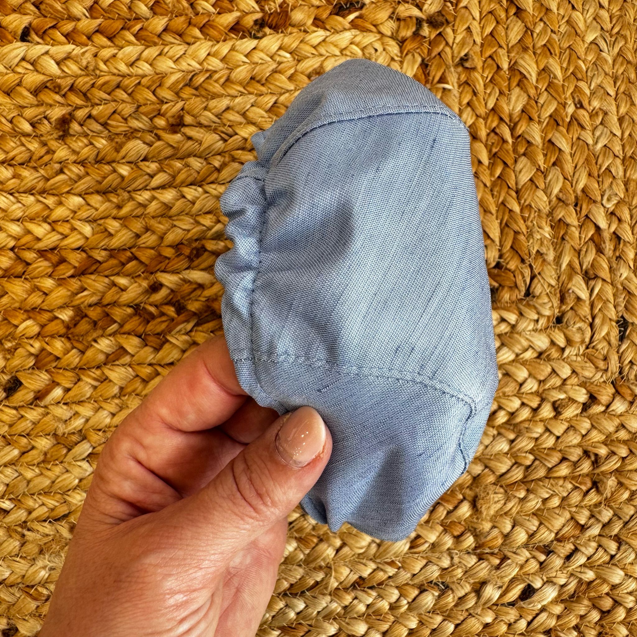 Cappellino in shantung azzurro con elastico posteriore, vista posteriore.