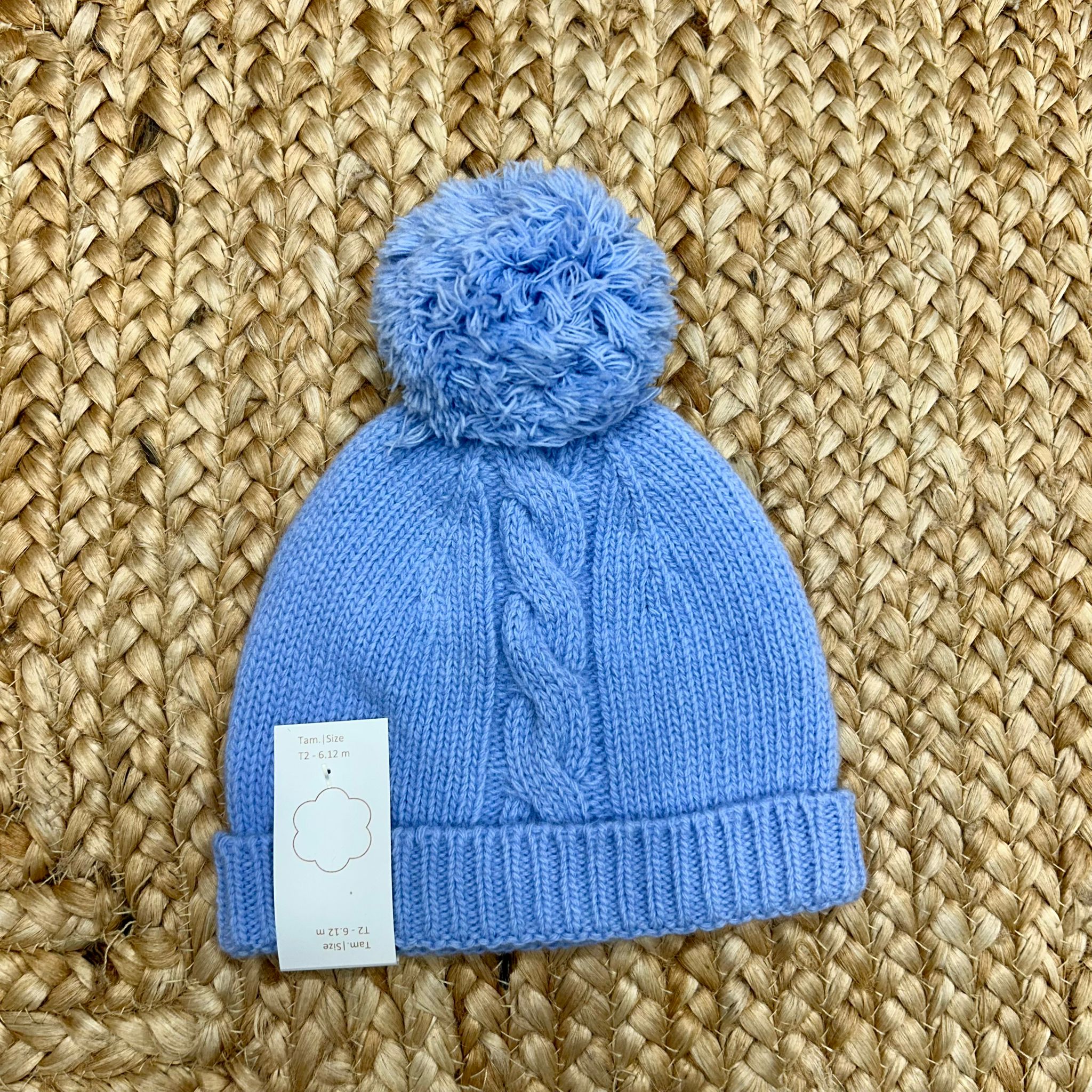 cappellino azzurro in pura lana con treccia centrale e pompon per neonato