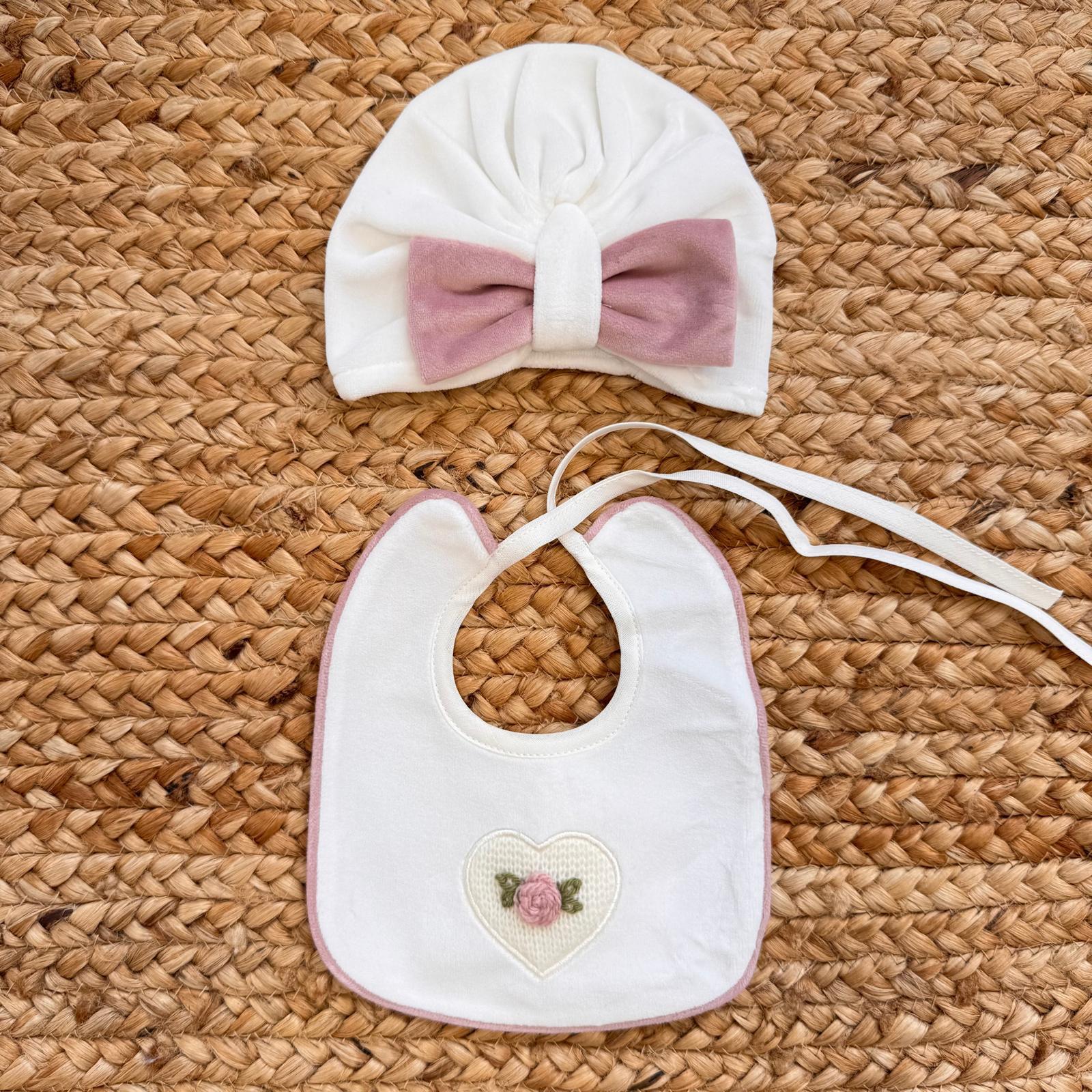 cappellino neonato con fiocco in ciniglia rosa cipria e bavetta coordinata con cuore ricamato