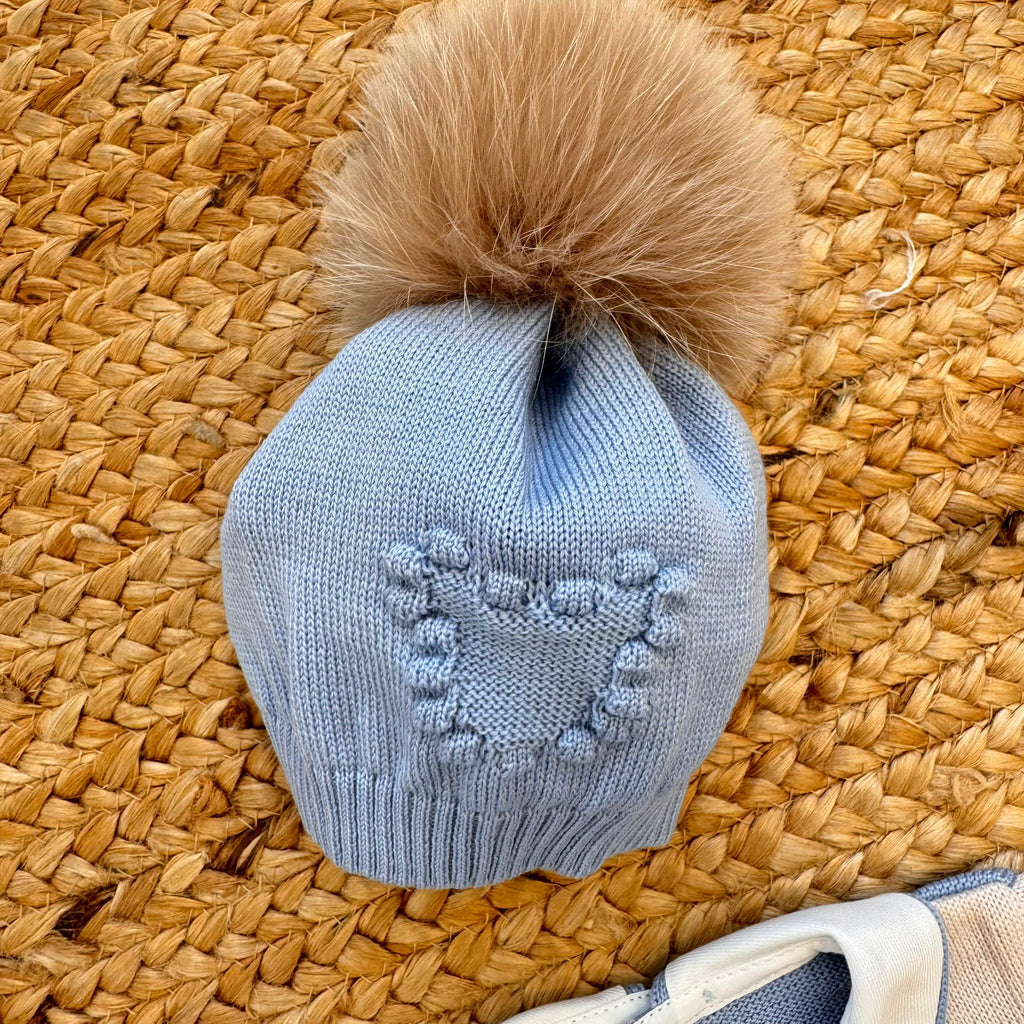 cappellino neonato in pura lana azzurra con pompon eco-pelliccia