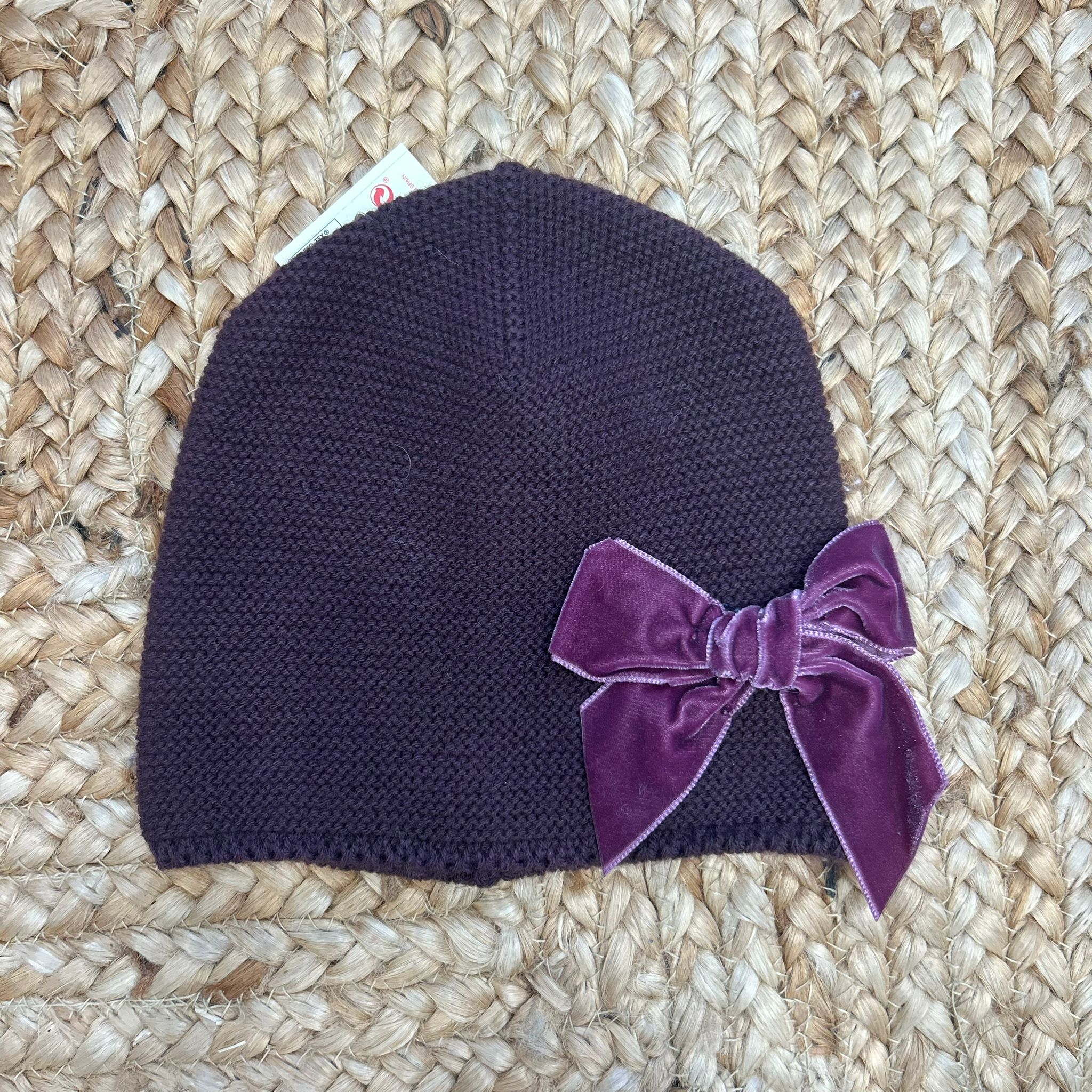 cappellino prugna in maglia con fiocco in velluto per bambina