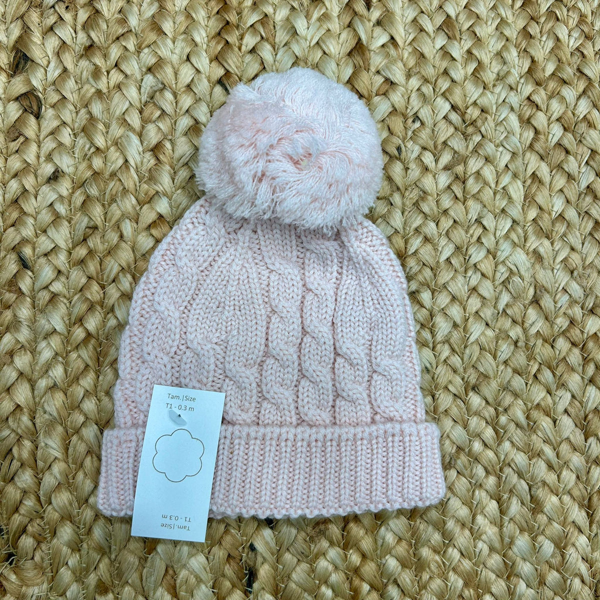 cappellino rosa in maglia intrecciata con grande pompon per neonata