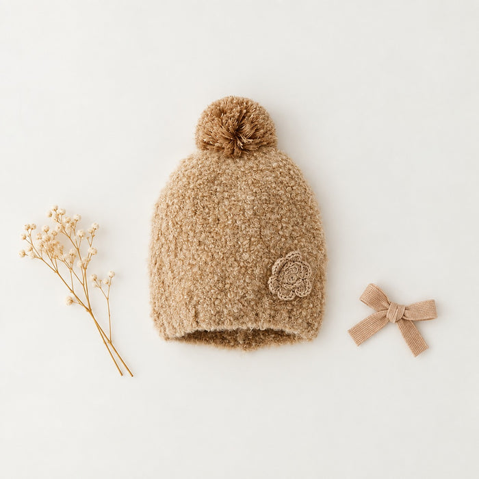 Cappello bimba beige con pompon, texture effetto bouclé e fiore decorativo applicato