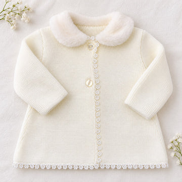 Cappottino battesimo bimba panna in maglia con colletto arrotondato effetto pelliccia, bottoni chiari e passamaneria floreale sul davanti.