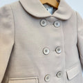 Cappottino bimba beige doppiopetto con colletto arrotondato, sei bottoni e tasche con patta