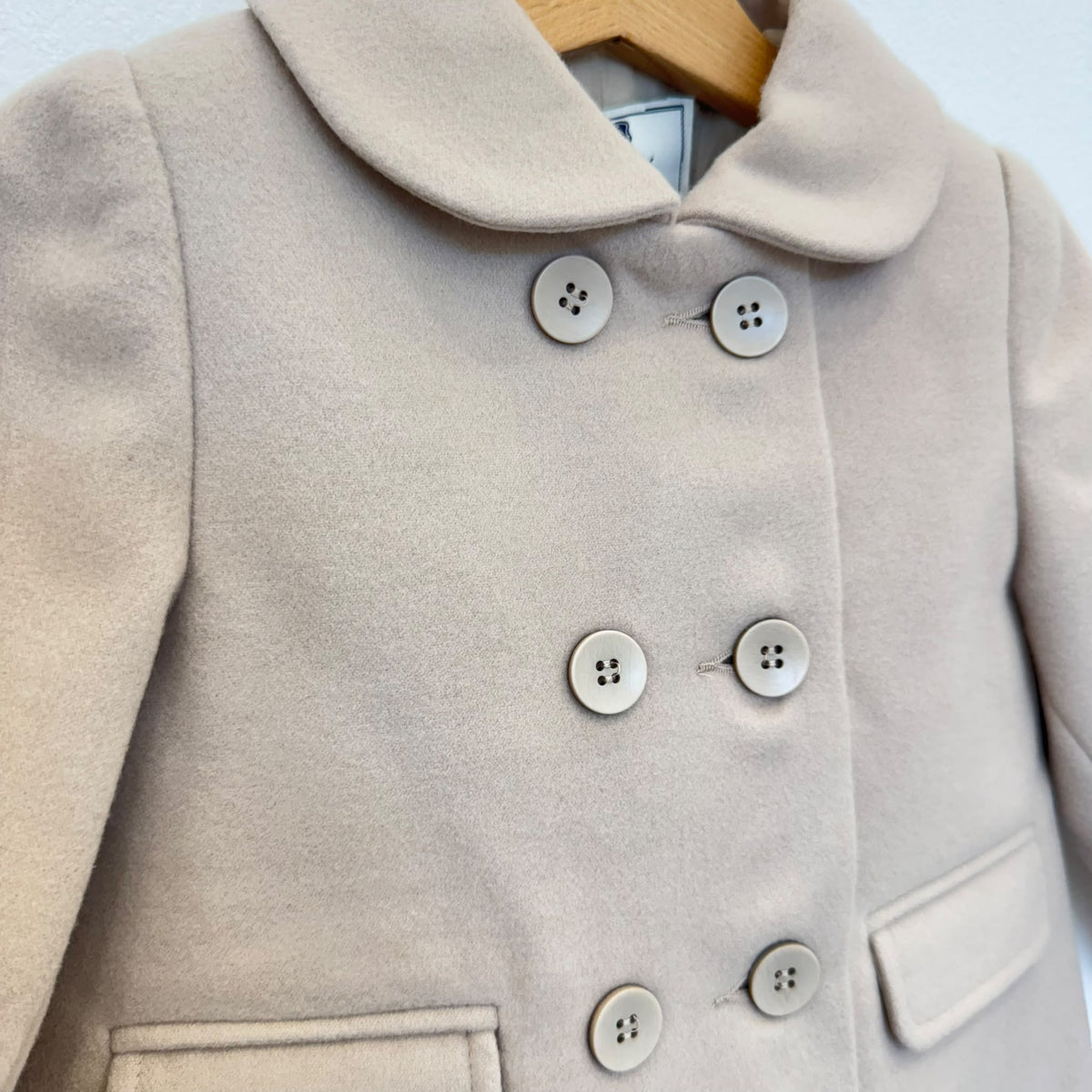 Cappottino bimba beige doppiopetto con colletto arrotondato, sei bottoni e tasche con patta