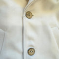 Cappotto bimbo elegante beige con cappuccio bordato in pelliccia, revers e bottoni effetto naturale