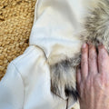 Cappotto bimbo elegante beige con cappuccio bordato in pelliccia, revers e bottoni effetto naturale