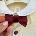 Dettaglio completo Battesimo bimbo bianco e bordeaux con cardigan in misto lana e papillon.