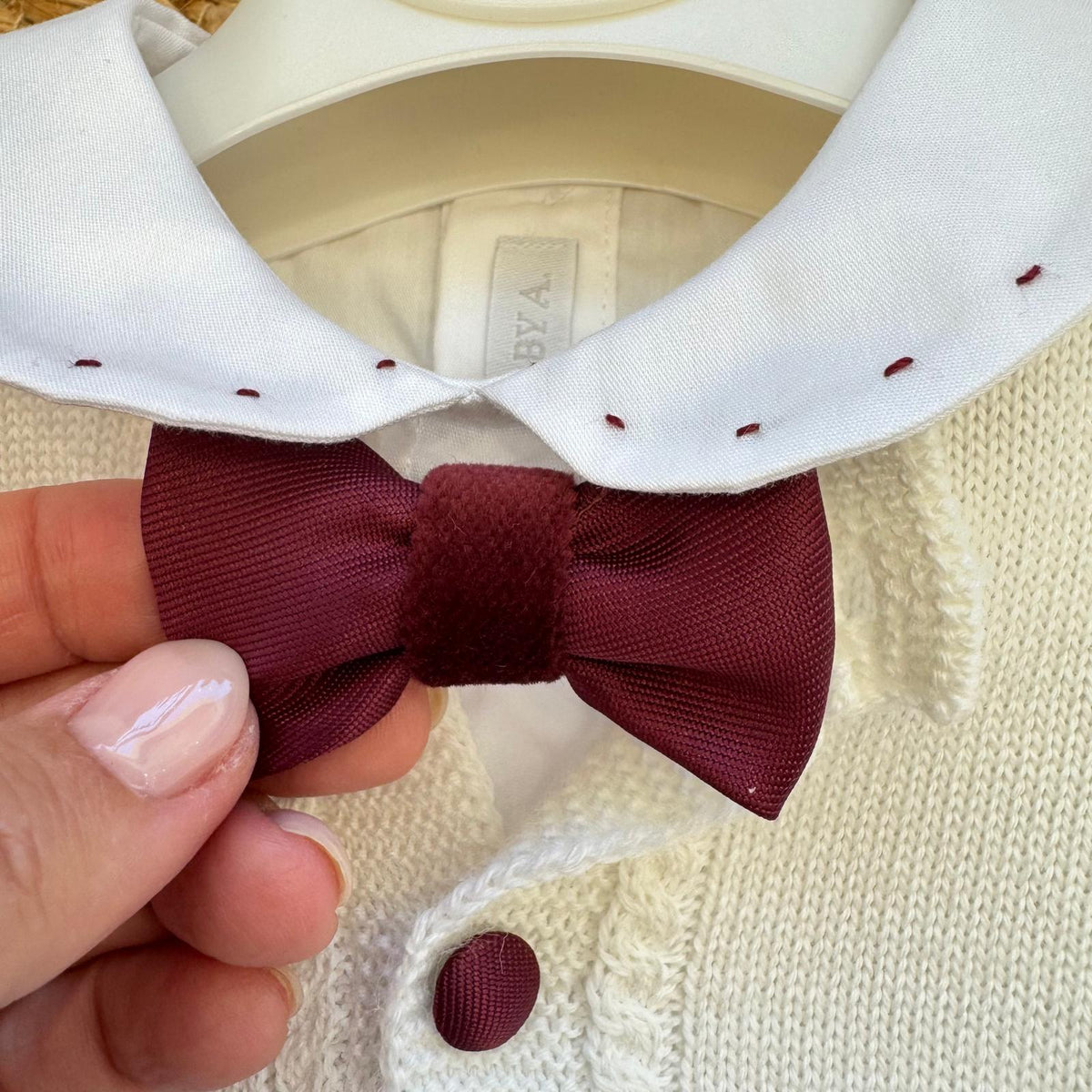 Dettaglio completo Battesimo bimbo bianco e bordeaux con cardigan in misto lana e papillon.