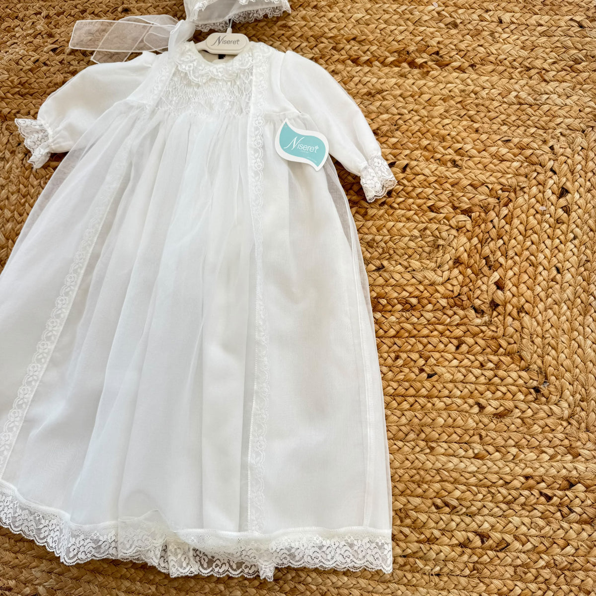 Abito battesimo bimba lungo bianco con punto smock, pizzo floreale e cuffietta coordinata