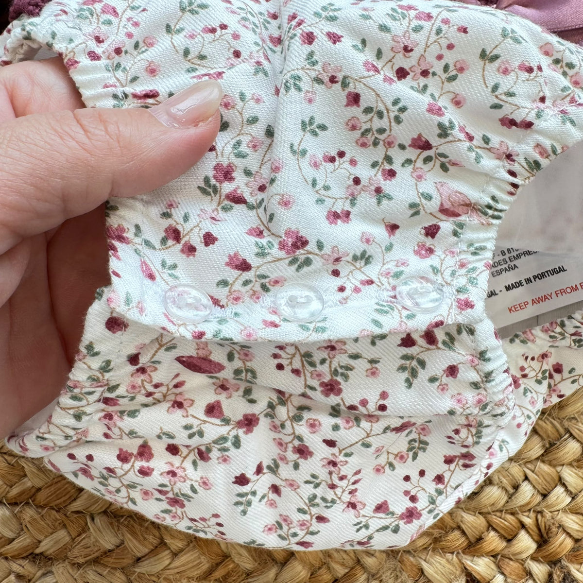 Pagliaccetto bimba in cotone vinaccio con fantasia floreale, colletto volant e fiocco rosa