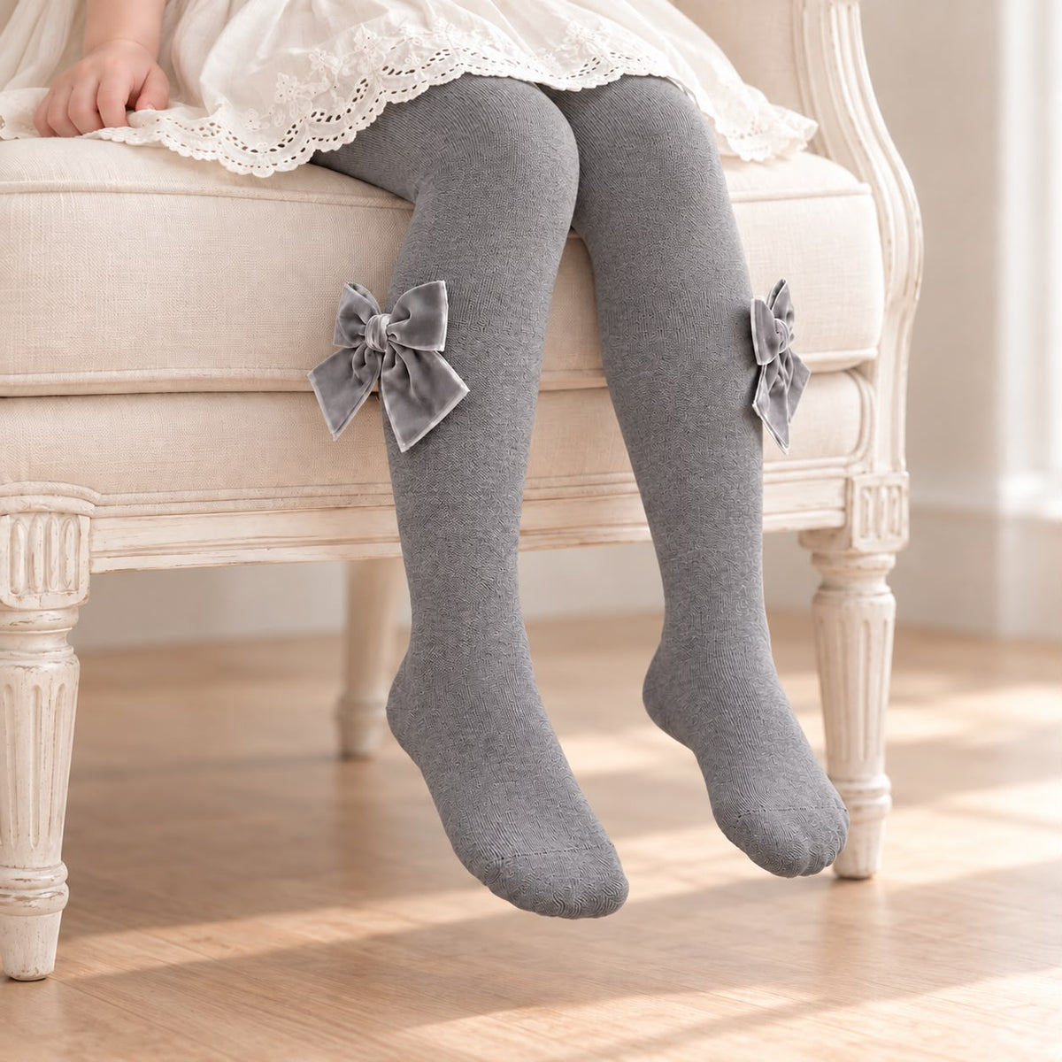 Collant bimba grigio con trama lavorata e grandi fiocchi laterali in velluto. Romantici e raffinati, perfetti con abitini e gonne. Da Belli e Monelli.