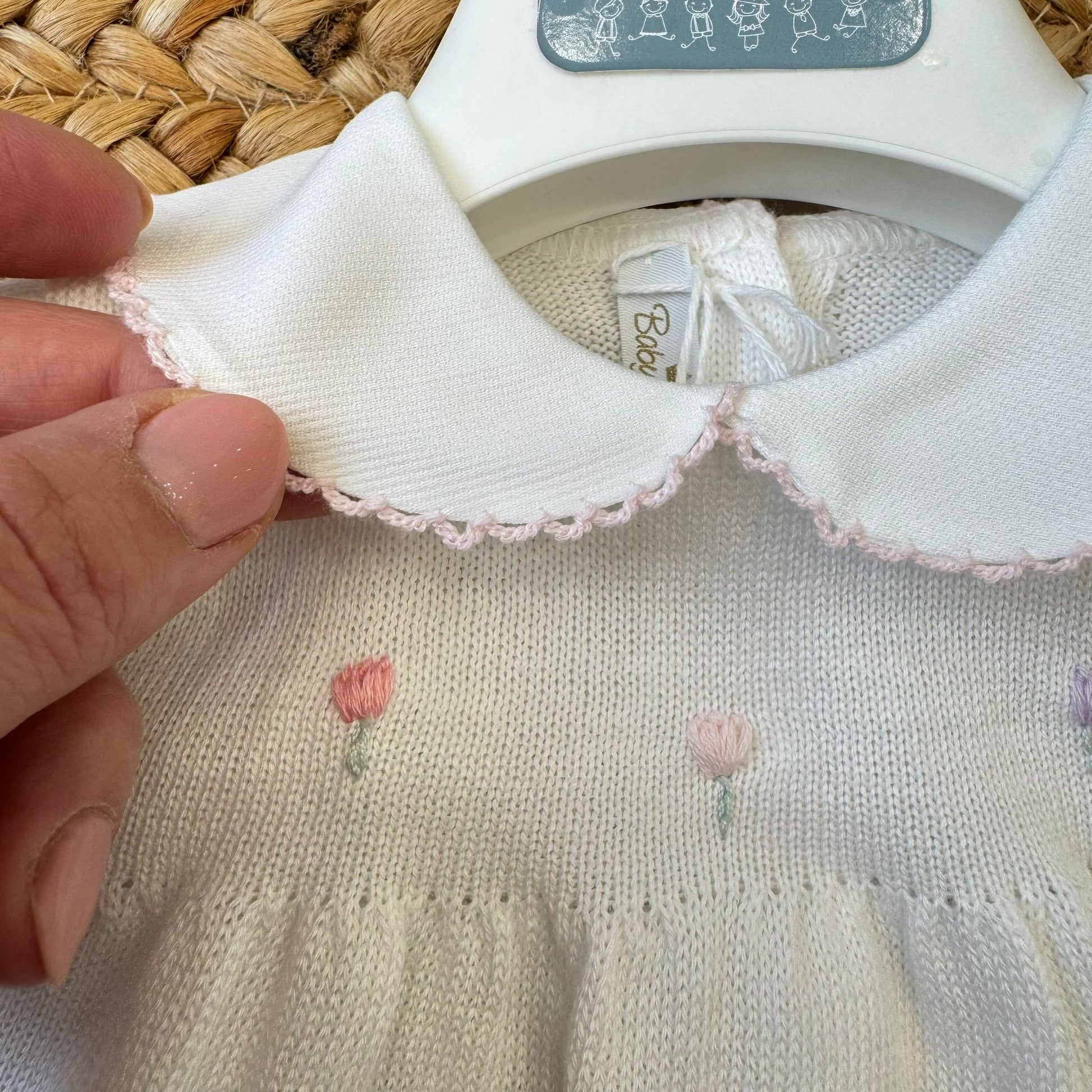 Dettaglio colletto bianco con profilo rosa tutina neonata