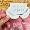 Tutina neonata in ciniglia rosa con ricamo floreale e fiocco elegante