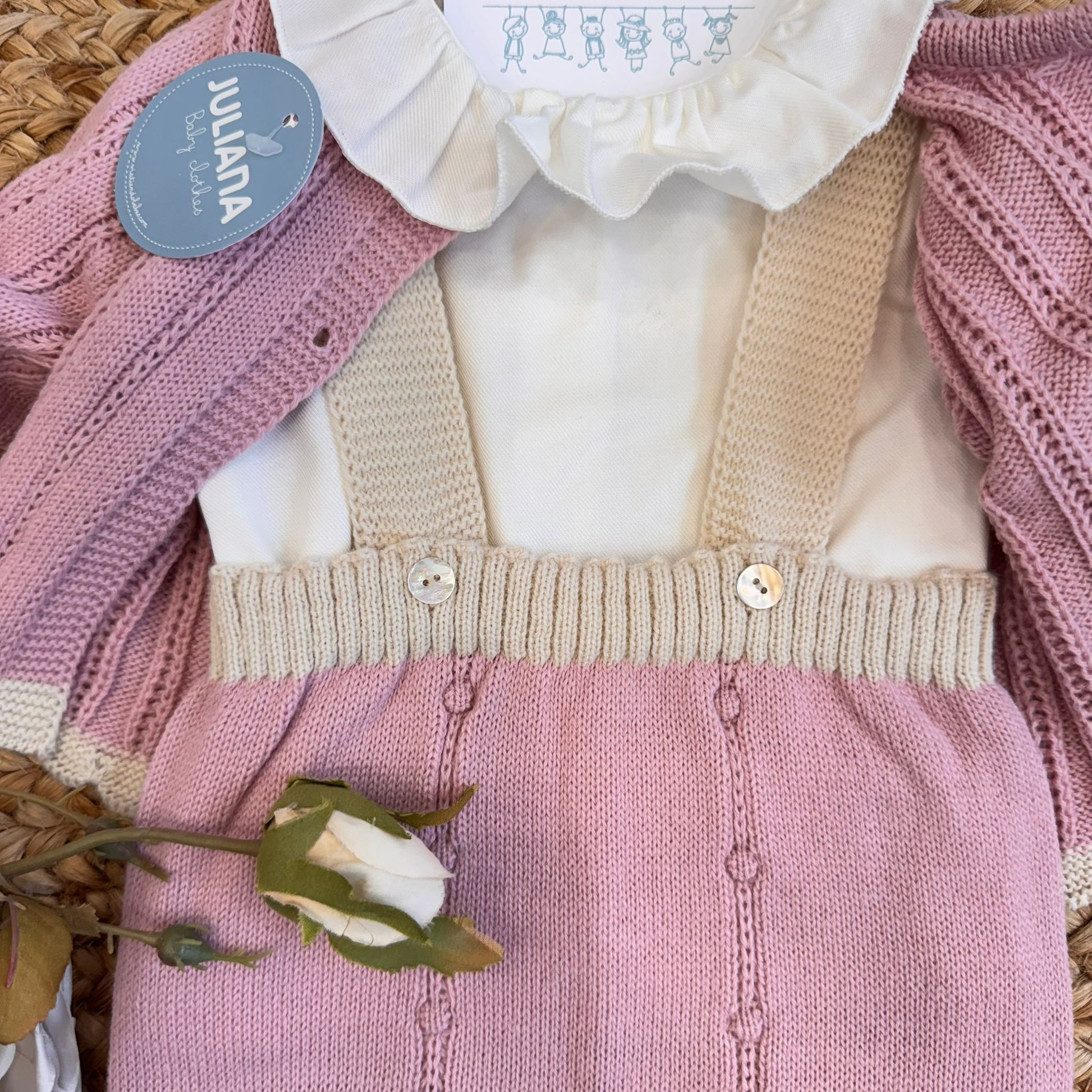 Colletto bianco in tessuto sul completo rosa da nascita

