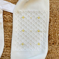Uscita clinica neonata in pura lana bianco latte con tutina, copertina, cappellino e scarpette con fiorellini gialli.