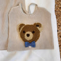 Dettaglio colletto ricamato della maglia beige da neonato
