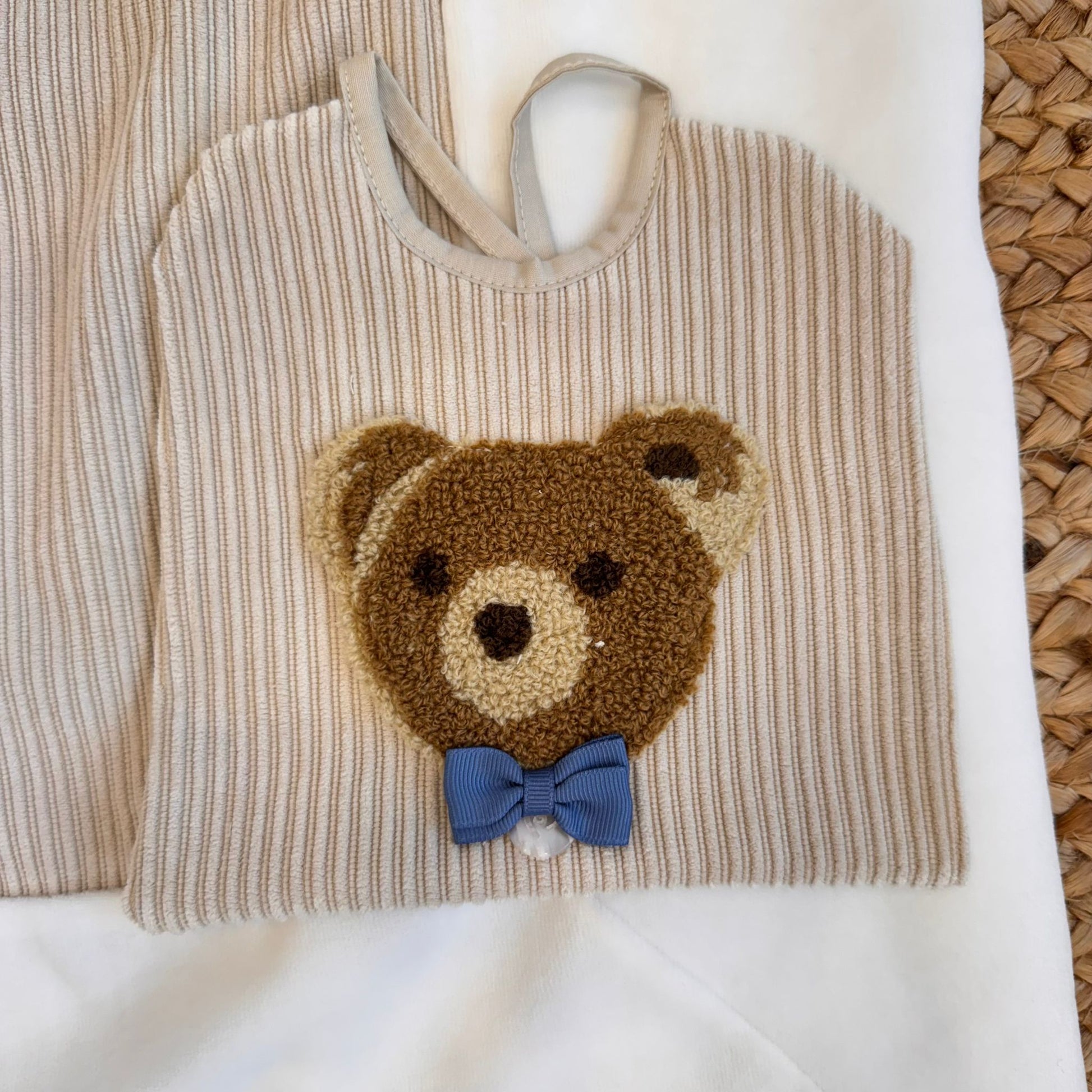 Dettaglio colletto ricamato della maglia beige da neonato