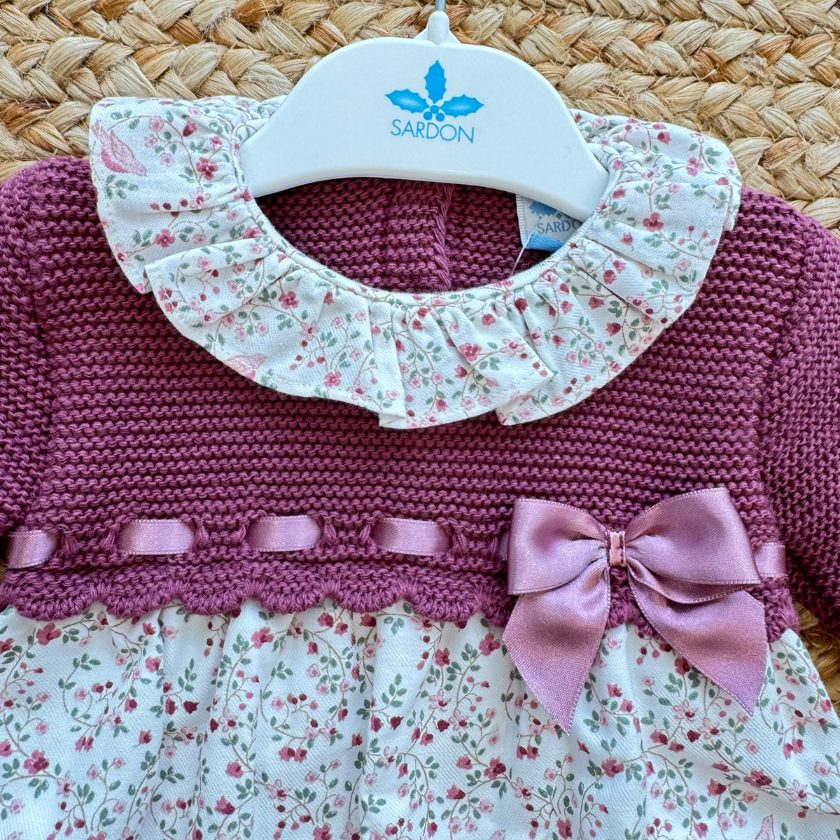 Pagliaccetto bimba in cotone vinaccio con fantasia floreale, colletto volant e fiocco rosa