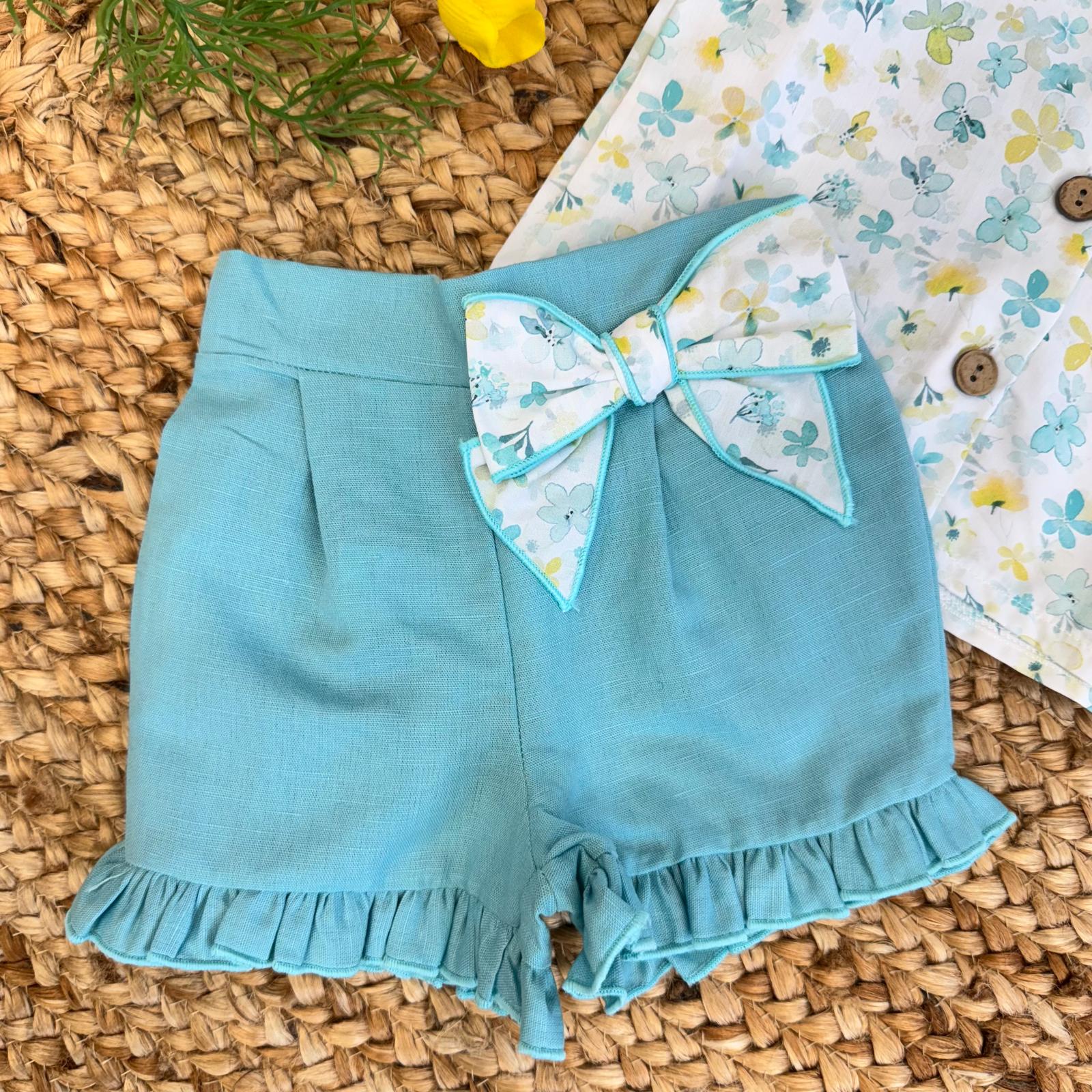 Dettaglio fiocco e volants sugli shorts.