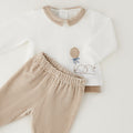 Dettaglio completo neonato in ciniglia bianco e beige con cagnolino, palloncino e pantalone a righe