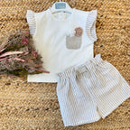  Completo bambina in cotone avorio con pantaloncini a righe beige, dettagli floreali e fiocco.