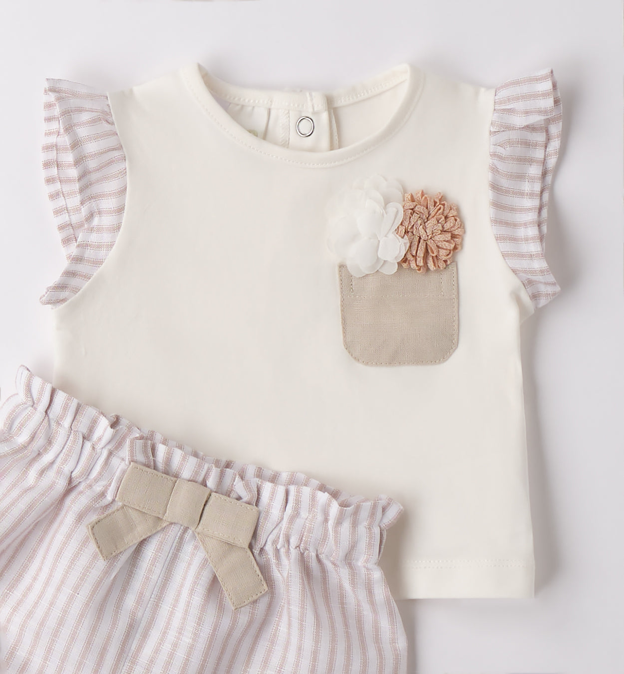 Dettaglio maglietta bambina con taschino in lino e fiori applicati, stile elegante