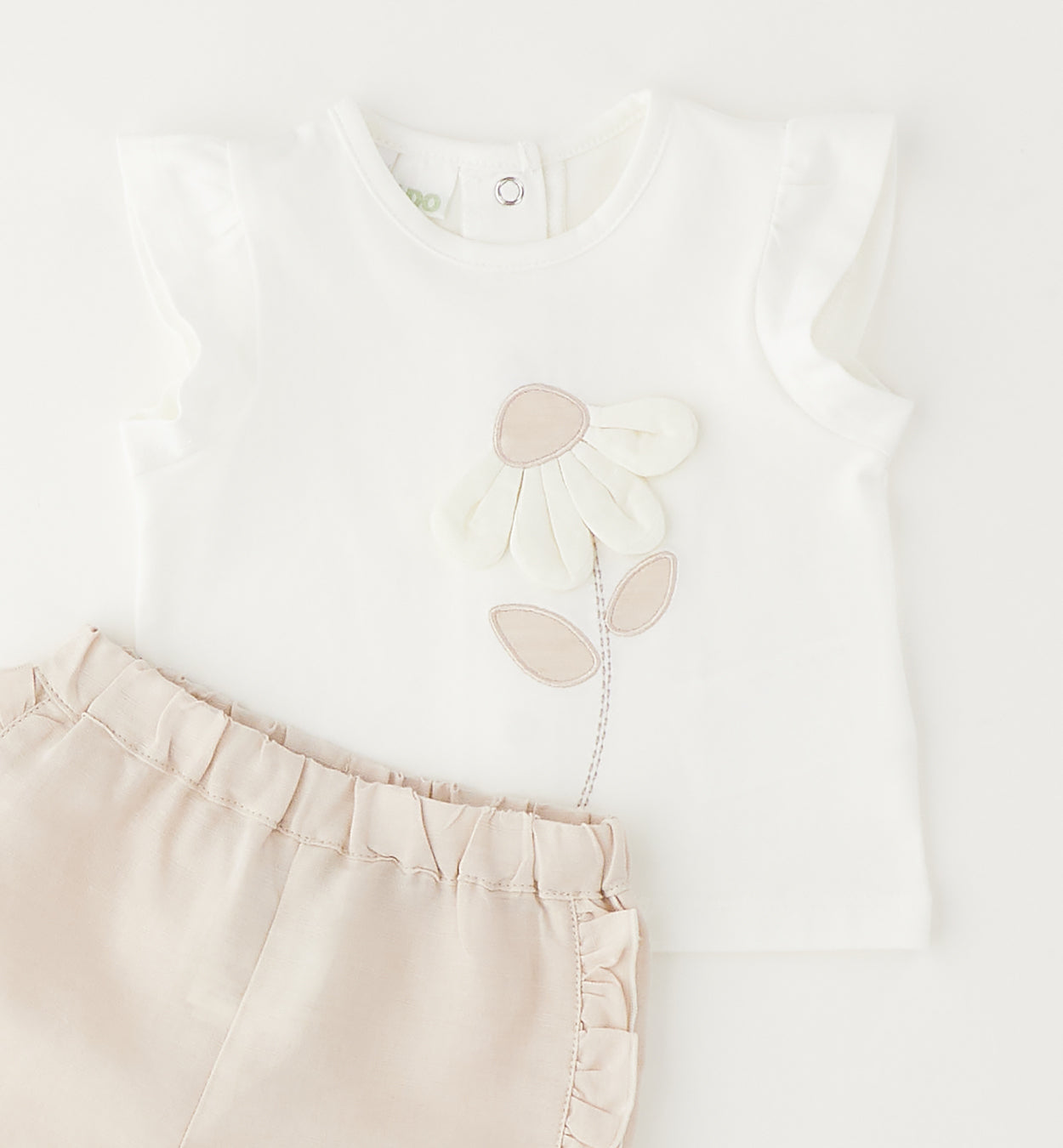 dettaglio completo bambina con maglia cotone fiore applicato e pantaloncino con rouche