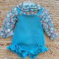 Completo bimba con salopette in maglia verde petrolio e camicia floreale a maniche lunghe