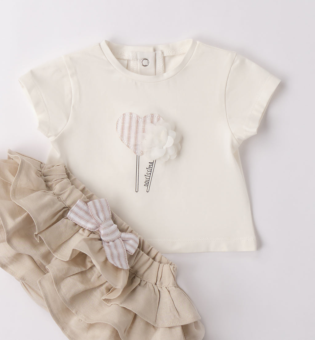 Completo bambina piegato con tessuti leggeri in cotone e lino, perfetto per la primavera e l'estate.
