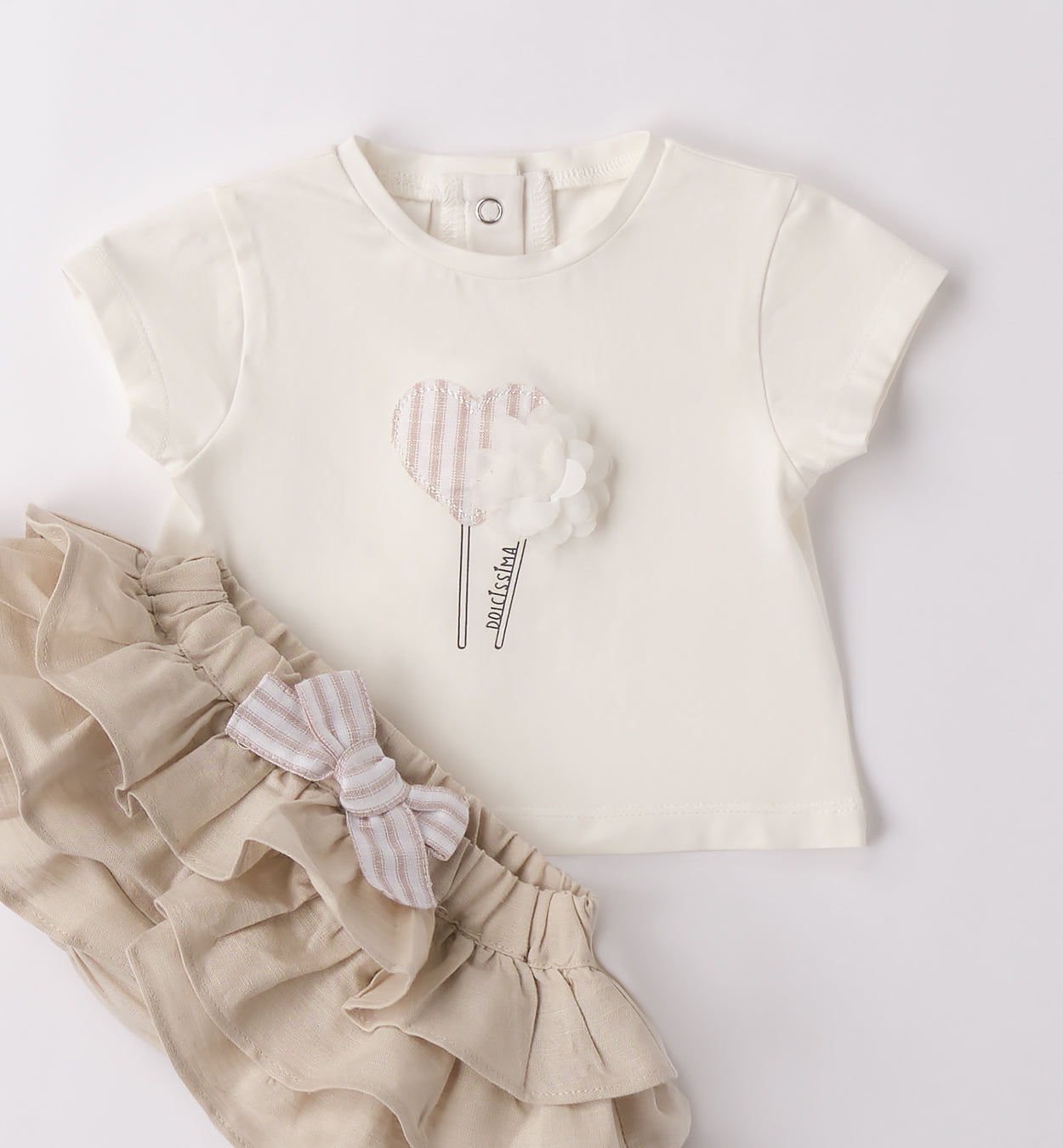 Completo bambina piegato con tessuti leggeri in cotone e lino, perfetto per la primavera e l'estate.
