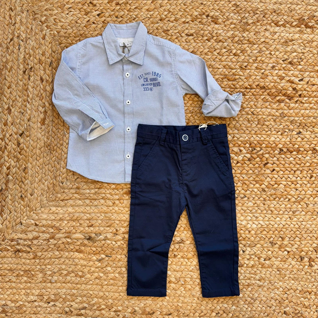 Completo bambino elegante con camicia azzurra e pantaloni blu in cotone.