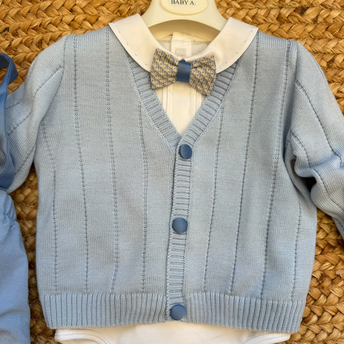 Cardigan azzurro del completo battesimo bimbo con camicia bianca e papillon fantasia.