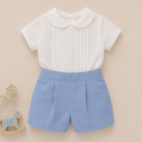 Completo battesimo bimbo azzurro e bianco con camicia a pieghe decorative e pantaloncino elegante.