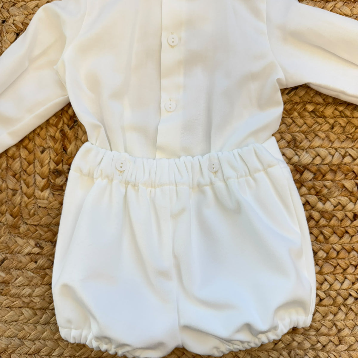 Completo battesimo neonato bianco con camicia a maniche lunghe decorata in pizzo floreale, papillon e pantaloncino a palloncino.