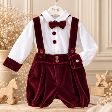 Retro completo battesimo bimbo con bretelle incrociate e fiocco in velluto bordeaux su camicia bianca.