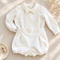 Completo battesimo neonato bianco con camicia a maniche lunghe decorata in pizzo floreale, papillon e pantaloncino a palloncino.