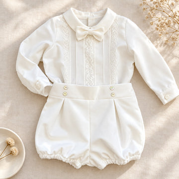 Completo battesimo neonato bianco con camicia a maniche lunghe decorata in pizzo floreale, papillon e pantaloncino a palloncino.