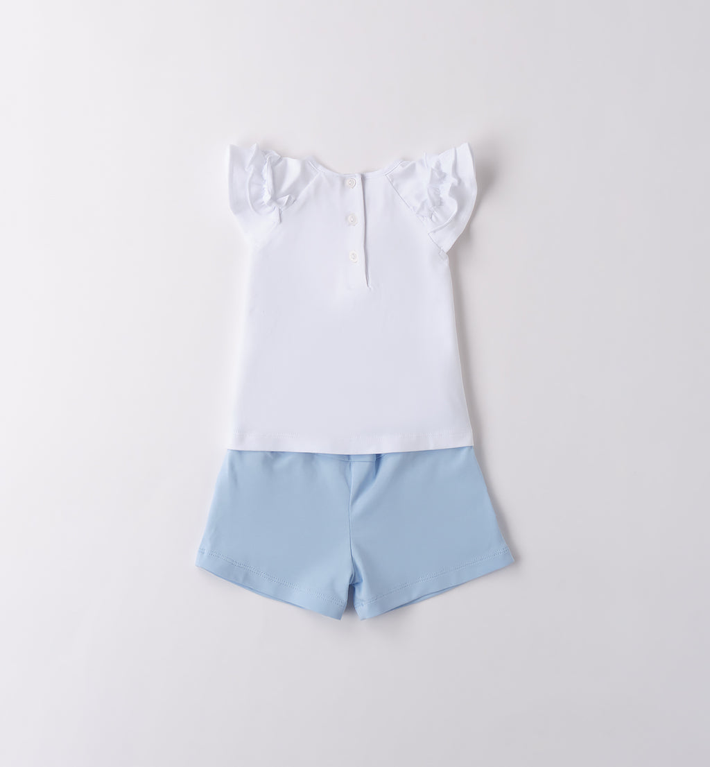  Completo bimba bianco e azzurro presentato con elementi decorativi naturali.