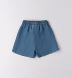 Outfit bimba rosso con denim su sfondo naturale