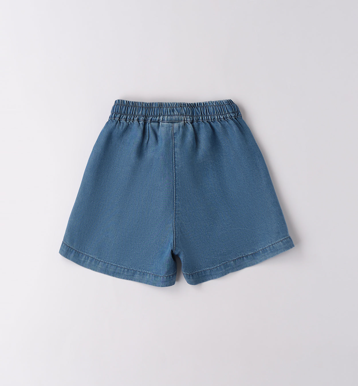 Outfit bimba rosso con denim su sfondo naturale