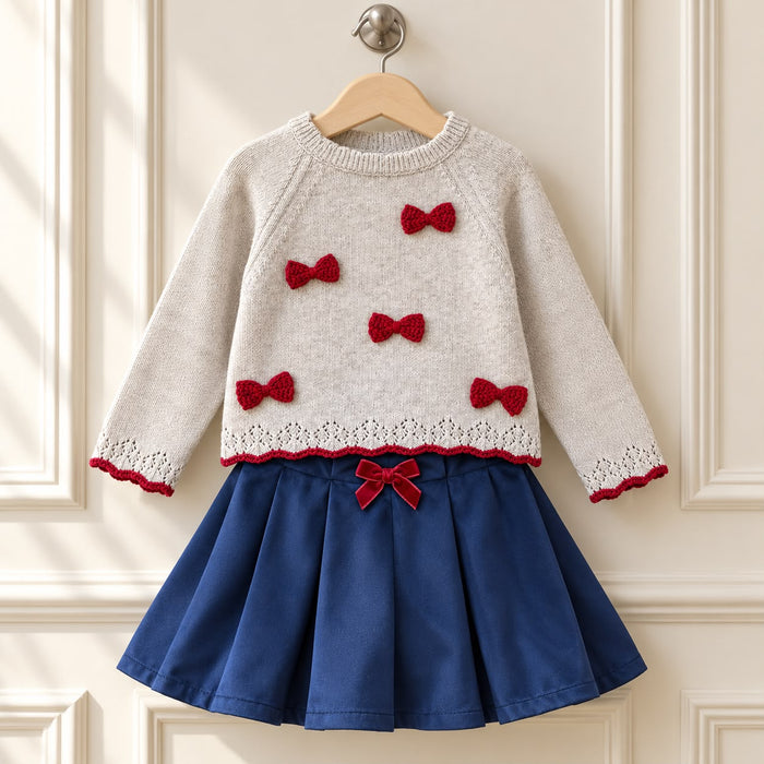 Completo bimba Dr.Kid con maglioncino beige a fiocchi rossi e gonna blu a pieghe con fiocco in velluto.