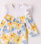 Completo estivo per bambina con stampa floreale nei toni del giallo e del blu, retro con bottoncini e volant sulle spalle.