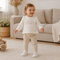 Completo bimba con maglia panna a manica lunga e pantalone beige con dettaglio volant e fiocchetto